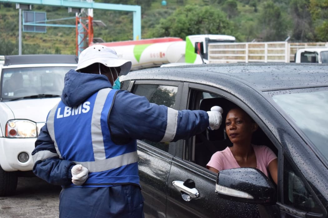 A Lesotho health official measures temperatures of motorists as a preventive measure against the spread of the COVID-19 coronavirus at the Maseru bridge in in Maseru, Lesotho, on March 10, 2020.