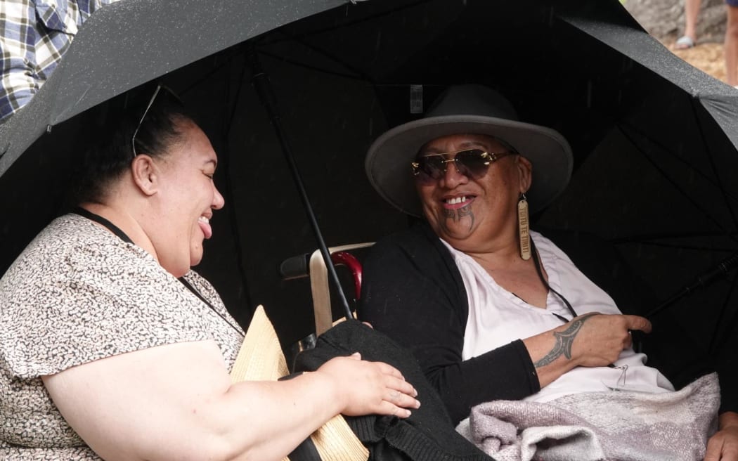 Spectators shelter from a sudden downpour at Te Whare Runanga on 3 February.