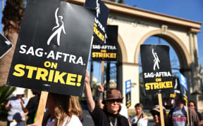 LOS ANGELES, CALIFORNIA - NOVEMBER 03: SAG-AFTRA member Caryn West (C) and other members and supporters picket outside Paramount Studios on day 113 of their strike against the Hollywood studios on November 3, 2023 in Los Angeles, California. Contract negotiations between the actors union and the Alliance of Motion Picture and Television Producers (AMPTP) are continuing in the strike which began on July 14.   Mario Tama/Getty Images/AFP (Photo by MARIO TAMA / GETTY IMAGES NORTH AMERICA / Getty Images via AFP)