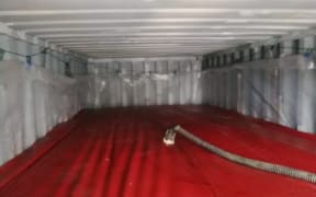 A large 'flexitank' bag inside a shipping container.