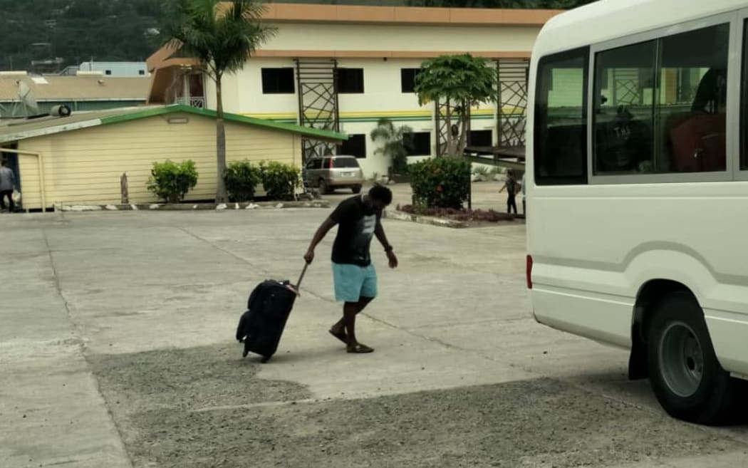 A refugee boards the bus to his new community accommodation shortly before being returned to his hotel.