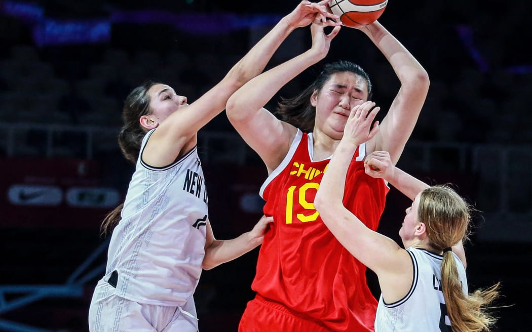 Chinese basketball player Zhang Ziyu (C) being challenged by New Zealand's Kavanah Faamaoni Lene (L) and Evie Leeson during their 2024 FIBA Under-18 Women's Asia Cup match.