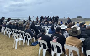 Whakatāne community sitting at the waterfront as karakia is held to mark the anniversary of the Whakaari White Island Eruption.