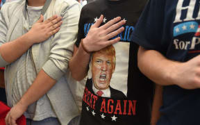 Supporters hold their hands over their hearts as they say the pledge of allegiance at a campaign rally by Republican presidential candidate Donald Trump, at the Henderson Pavilion, October 5, 2016 in Henderson, Nevada.