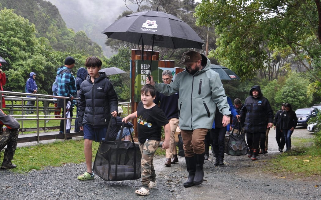 Ngāti Koata Trust members carrying the tuatara into the Brook Waimārama Sanctuary.