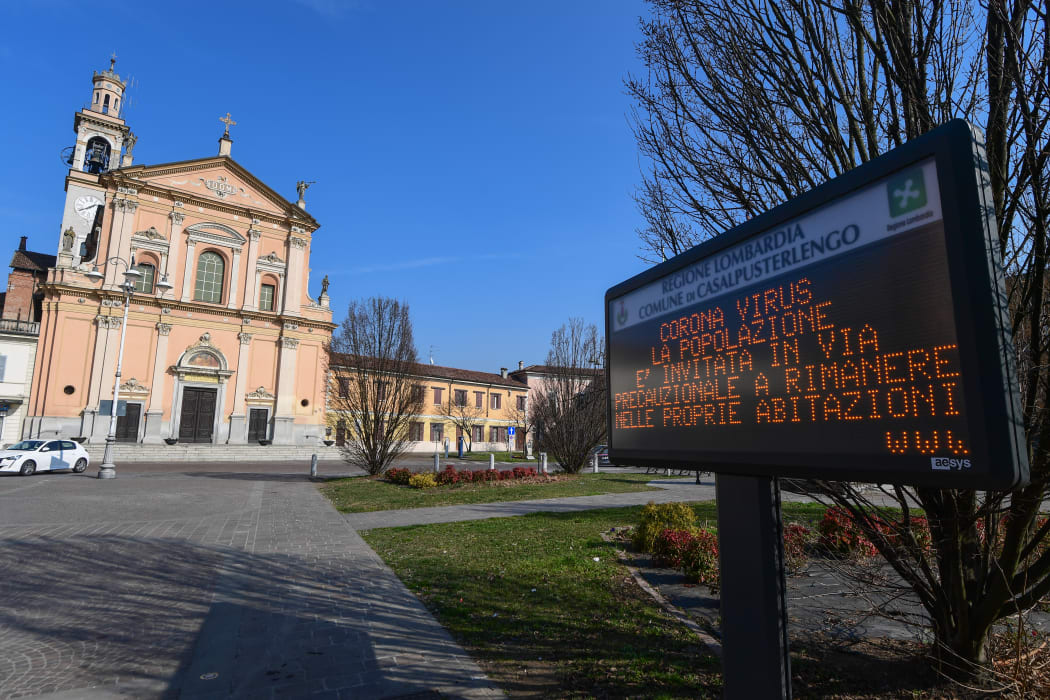 A municipal information sign reads "Coronavirus, the population is invited as a precautionary measure to remain at home" is pictured in the village of Casalpusterlengo, southeast of Milan