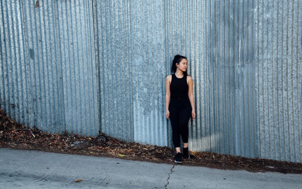 Portrait of young woman standing in front of corrugated fencing (Photo by Ashley Corbin-Teich / Image Source / Image Source via AFP)