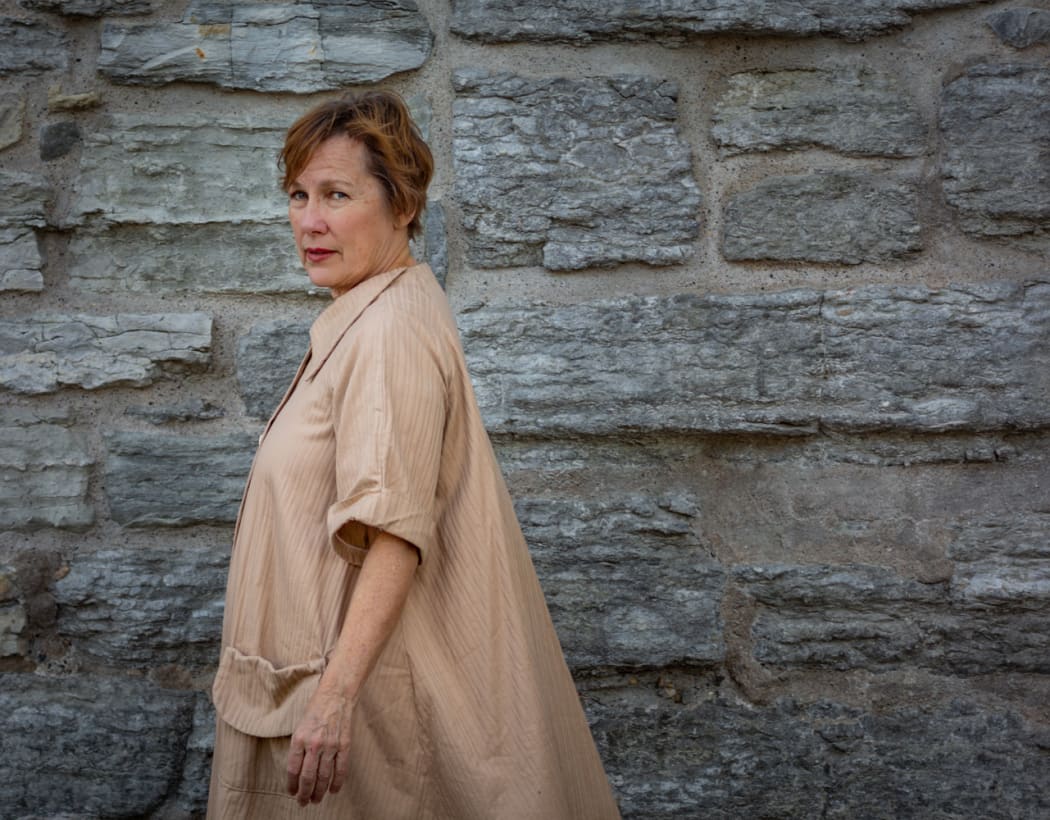 American singer-songwriter Iris DeMent against a rock wall