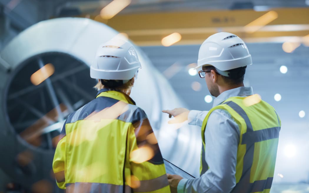 Two Heavy Industry Engineers Stand in Pipe Manufacturing Factory,