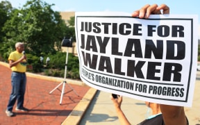 NEWARK, NEW JERSEY - JULY 15: A person holds a sign as people gather for a rally demanding justice for Jayland Walker on at Essex County Historic Courthouse on July 15, 2022 in Newark, New Jersey. The People’s Organization for Progress (POP) organized a march and rally to demand justice for Jayland Walker, who was killed in Akron, Ohio by police on June 27, 2022. According to a medical examiner's report released today Walker, who was unarmed at the time, suffered 46 gunshot wounds after multiple police officers shot at him an estimated 90 times following a car chase. The family held an open casket funeral for Walker on July 13th, and drew comparisons to a choice by Emmett Till’s mother 67 years ago that helped galvanize the national Civil Rights Movement.   Michael M. Santiago/Getty Images/AFP (Photo by Michael M. Santiago / GETTY IMAGES NORTH AMERICA / Getty Images via AFP)