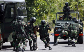 Indonesia Army Special Forces soldiers (Kopassus) perform a quick attack during a simulated hostage bus hijacking drill in their headquarters complex in Kandang Menjangan, Sukoharjo, Central Java, Indonesia, on Monday, September 16, 2013.