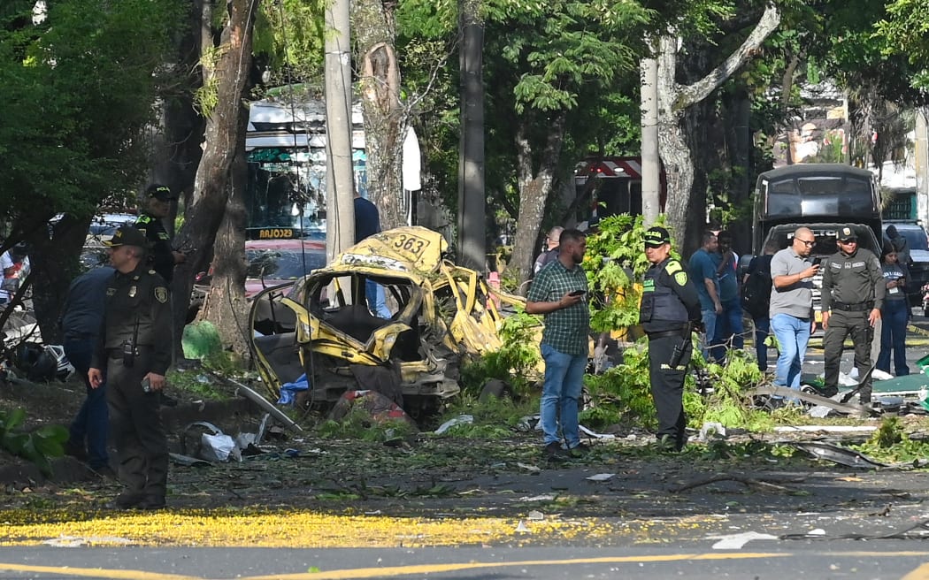 Members of the Colombian police inspect the area of a bomb explosion in cali, Colombia on August 21 2025. Five people were killed and dozens were injured when a vehicle bomb targeted a military base on a busy street in the Colombian city of Cali on August 21, 2025, local authorities said. (Photo by Oswaldo Páez / AFP)