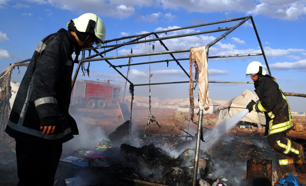 Firefighters extinguish a fire after a Syrian regime warcraft targeted the Kamuna refugee camp near the Sarmada town of Idlib province, Syria on May 05, 2016.