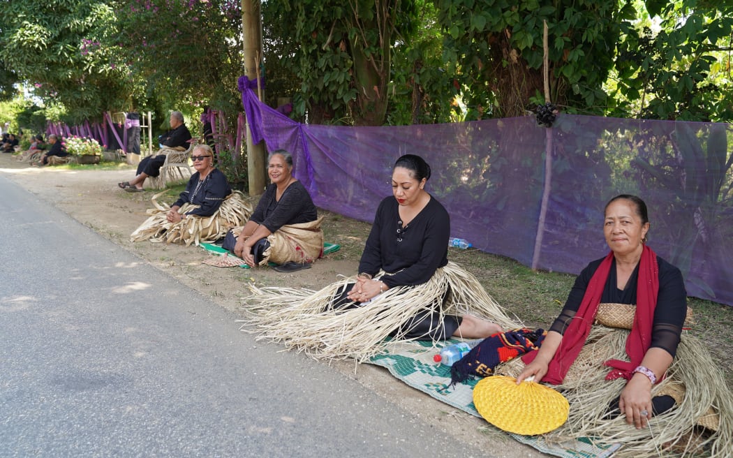 Mourners in Tonga wearing funeral mats sat on the roadside to pay their respects.