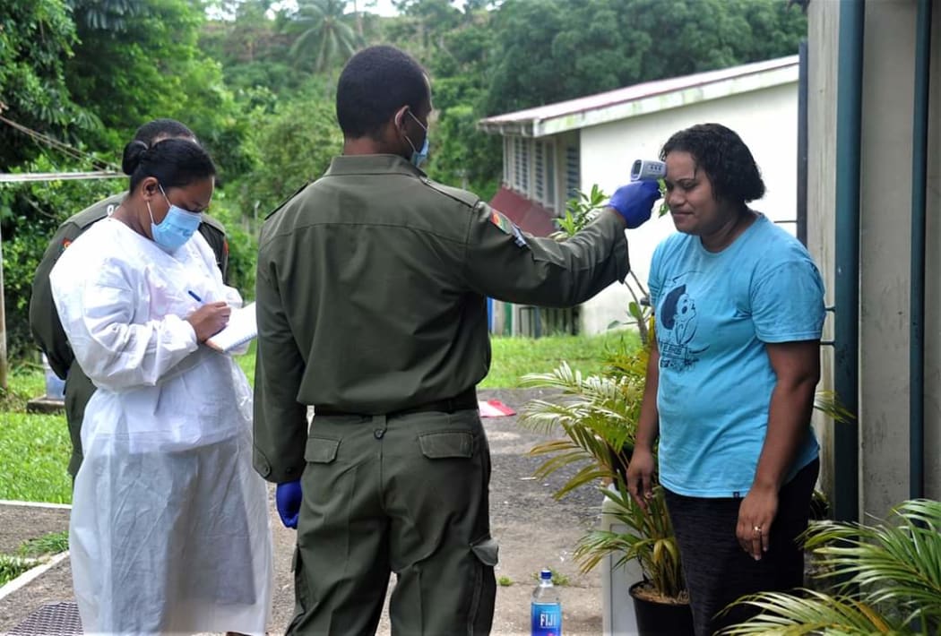 A soldier helps mobile screening teams carry out door-to-door tests in Suva.