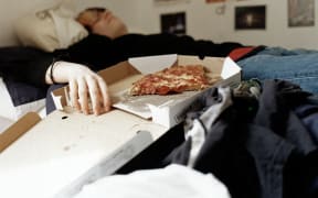 Boy sleeping with pizza on bed (Photo by Alys Tomlinson / Image Source / Image Source via AFP)