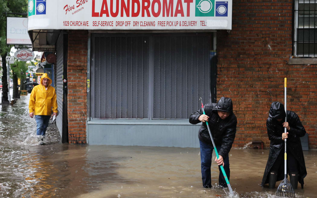 NEW YORK, NEW YORK - SEPTEMBER 29: People attempt to clear a storm drain on Stratford Avenue amid a coastal storm on September 29, 2023 in the Flatbush neighborhood of Brooklyn borough New York City. Flash flooding is expected in the counties of Nassau, Queens and Kings, which includes Brooklyn, according to the state’s National Weather Service office as remnants of Tropical Storm Ophelia reaches the Northeast. Gov. Kathy Hochul has declared a state of emergency for the NYC area.   Michael M. Santiago/Getty Images/AFP (Photo by Michael M. Santiago / GETTY IMAGES NORTH AMERICA / Getty Images via AFP)