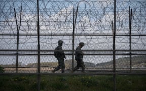 South Korean soldiers patrol along a barbed wire fence Demilitarized Zone (DMZ) separating North and South Korea, on the South Korean island of Ganghwa on April 23, 2020.