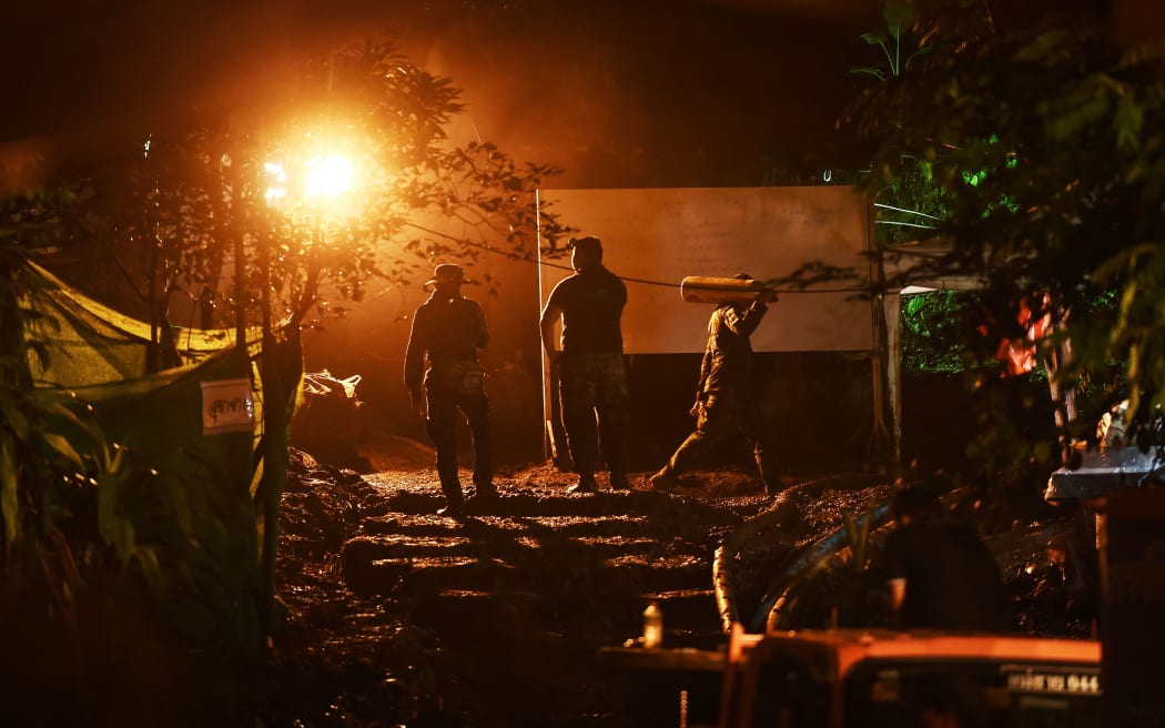 Rescue workers carry oxygen tanks to Tham Luang cave.