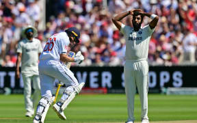 India's Jasprit Bumrah (R) reacts as England's Joe Root (L) celebrates reaching his century on the second day of the third cricket test match between England and India at Lord's cricket ground in London, on July 11, 2025. (Photo by Ben STANSALL / AFP) / RESTRICTED TO EDITORIAL USE. NO ASSOCIATION WITH DIRECT COMPETITOR OF SPONSOR, PARTNER, OR SUPPLIER OF THE ECB