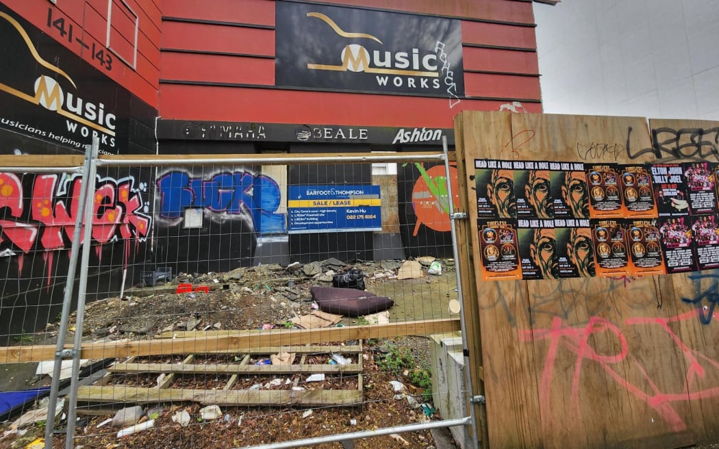 The front of a building that has rubbish strewn in front of it.