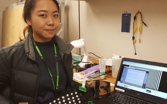 Sarah Jeong holding the electrogastrography belt, which is covered with electrodes to measure electrical signals from the gut.