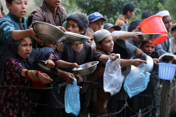 In this photograph taken on June 6, 2016, young children wait as an Afghan man distributes food for the needy during the first day of the Islamic holy month of Ramadan in Ghazni province. Across the Muslim world, the faithful fast from dawn to dusk and strive to be more pious during the holy month, which ends with the Eid holiday.