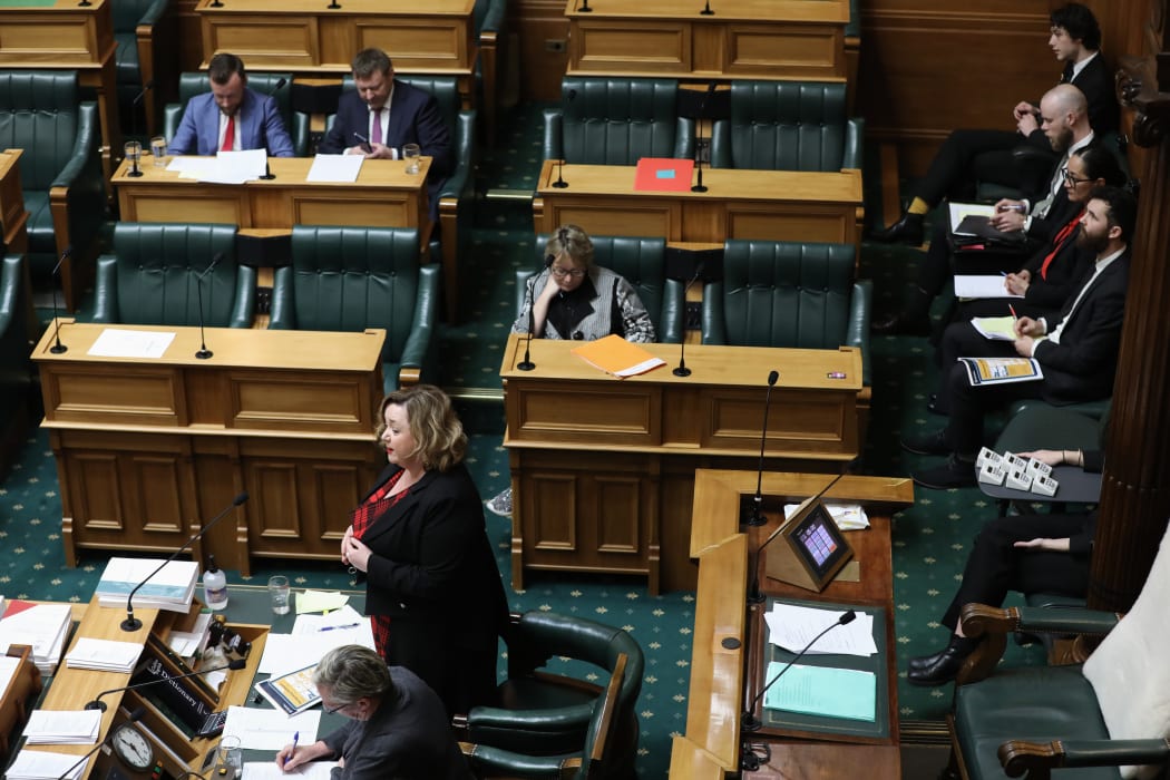 Megan Woods answers MPs Estimates questions from the Table while ministry officials line up (top right) available to provide further information