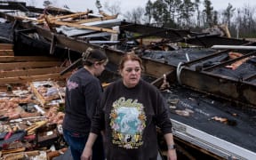 Denise Woodard looks over her destroyed home at Harmony Hills trailer park, where many homes were damaged on destroyed in severe weather, on 15 March, 2025, in Poplar Bluff, Missouri.