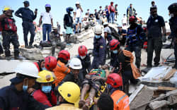EDITORS NOTE: Graphic content / Venezuelan Civil Protection members and firefighters rescue 21-year-old Patrick Vargas from the rubble of a collapsed building in Catia La Mar, La Guaira, Venezuela, on June 26, 2026, following earthquakes. The death toll from two powerful earthquakes that devastated Venezuela earlier this week rose to 920 on June 26, National Assembly President Jorge Rodriguez said. (Photo by Federico PARRA / AFP)