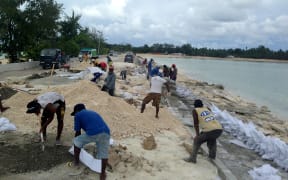 Sand bagging the beach to stop erosion in Tarawa, Kiribati.