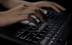 A person typing on an intergrated Māori keyboard.