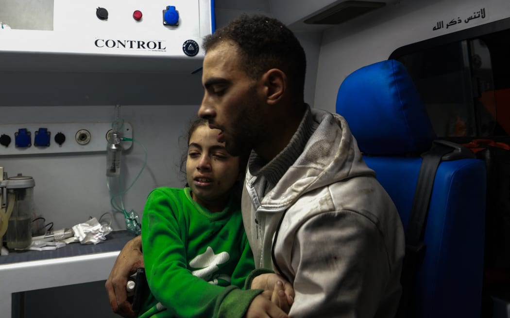 A father holds his wounded daughter in hospital following Israeli bombardments over Rafah in the southern Gaza Strip.