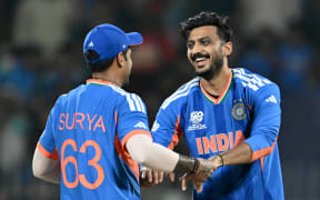 India's Axar Patel (R) celebrates with captain Suryakumar Yadav after taking the wicket of Zimbabwe's Tadiwanashe Marumani.