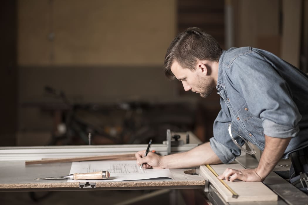 Carpenter looking at the plans, joiner, small business