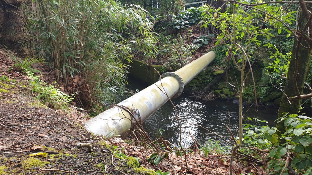 An exposed pipe over the Huatoki River.