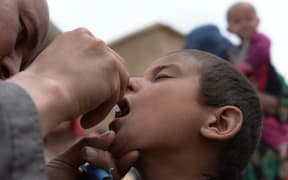 A child receives polio vaccination drops after the landslide disaster in Badakhshan, Afghanistan.