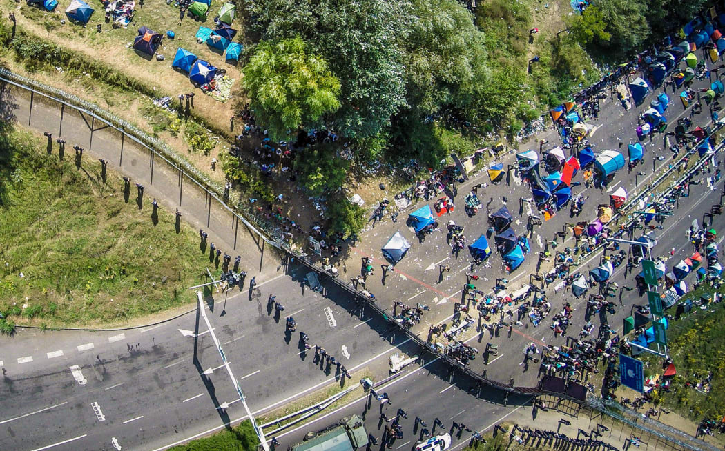 An aerial view taken on September 16 shows migrants camping on no-man's land of the border between Hungary and Serbia near Roeeszke. Hungarian police used tear gas and water cannon against migrants to push them from Hungary's territory. AFP PHOTO / ISTVAN RUZSA