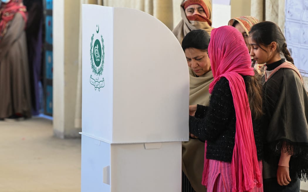 Women cast their ballot at a polling station during Pakistan's national elections in Islamabad on February 8, 2024. Pakistan suspended mobile phone and data services nationwide on February 8 for election day, in a move a digital rights group said was "inherently undemocratic". (Photo by Farooq NAEEM / AFP)