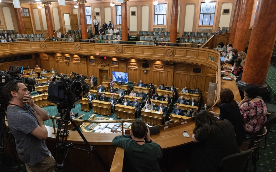 Ukrainian President Volodymyr Zelensky listens to Prime Minister Jacinda Ardern's response to his address to the New Zealand House of Representatives.