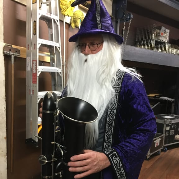 NZSO bassoonist David Angus is dressed as a wizard in purple robes for an orchestra concert.