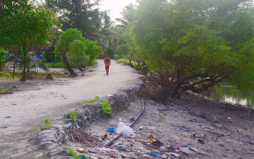 child walks along  unsealed road