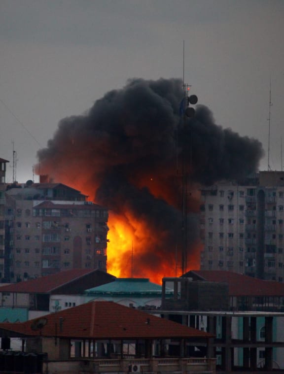 A ball of fire rises from a building after an Israeli air strike in Gaza City.