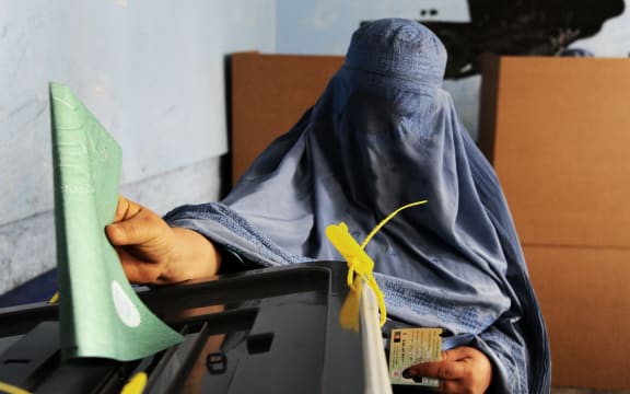 An Afghan woman casts her ballot at a polling station in the northwestern city of Herat.