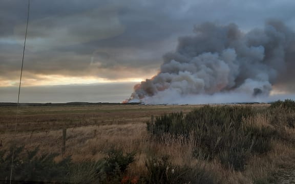 Smoke from a fire burning through 1000 hectares of manuka scrub and peat soils at Awarua, south of Invercargill, on 3 April, 2022.
