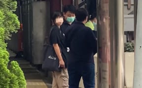 Chow Hang-tung (L), barrister and a leader of the Hong Kong Alliance in Support of Patriotic Democratic Movements of China, being led away by plainclothes police officers after being detained in Hong Kong on June 4, 2021, the anniversary of Beijing's deadly Tiananmen crackdown.