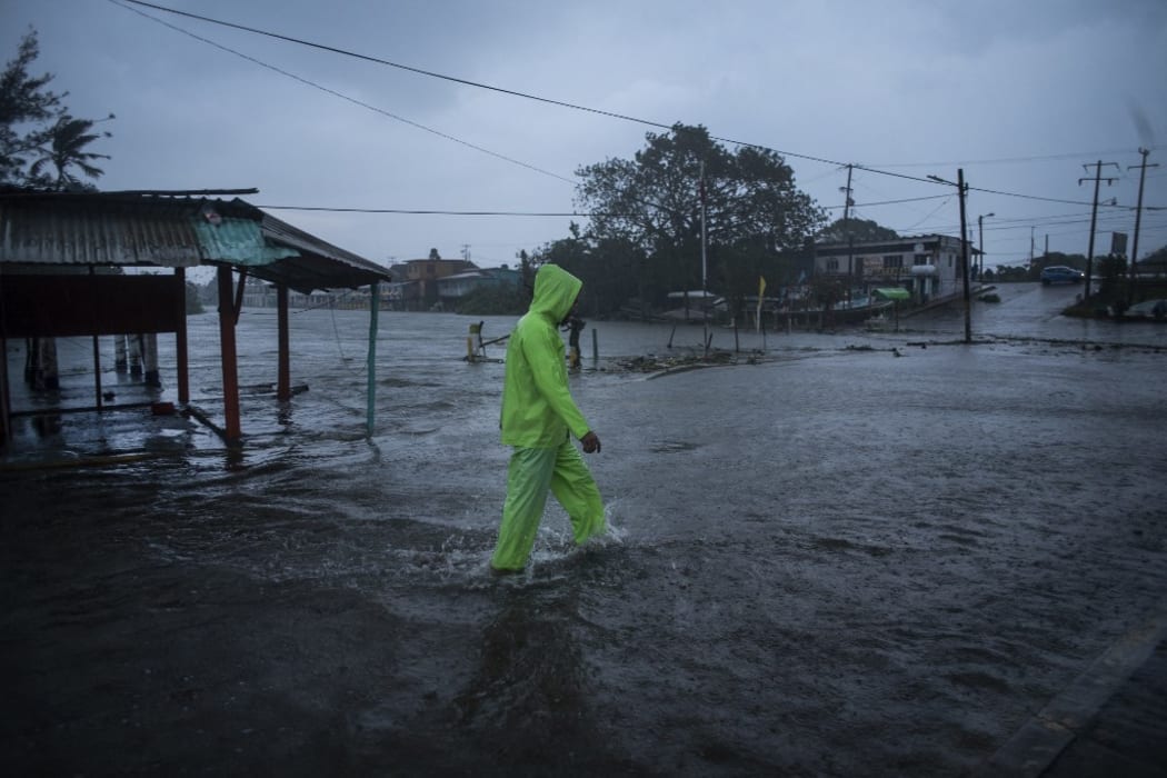 A man walks in a flooded street due to heavy rains caused by Hurricane Grace in Tecolutla, Veracruz, Mexico, on August 21, 2021.
