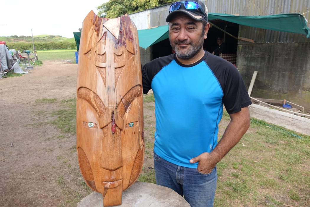Turangi carver Nata Te Pona working and with his piece the Thin Line.
