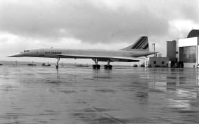 A left side view of an Air France Concorde supersonic passenger aircraft parked on the flight line during a stopover at the air station.