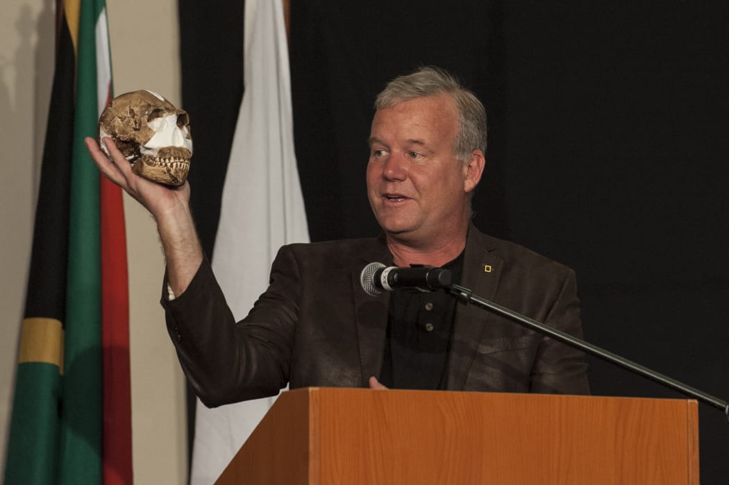 Professor Lee Berger holding up a Homo naledi skull at a press conference in Maropeng, South Africa.